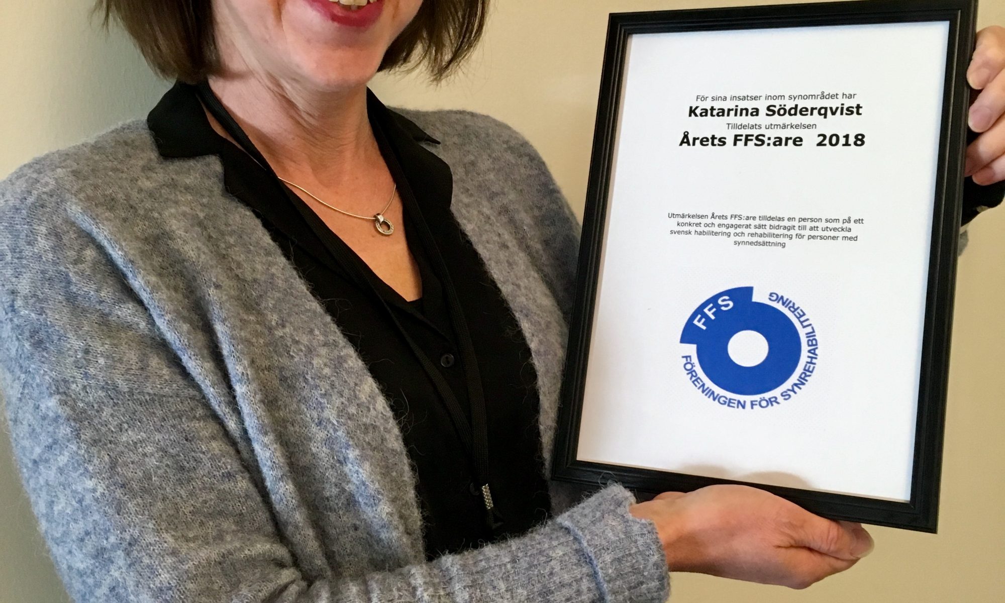 Foto av Katarina som håller upp den inramade utmärkelsen/diplomet årets Ffs:are 2018
