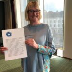 Foto av Annika Södergren som håller upp ett A4 ark med motiveringen till hennes utnämning årets FFS are 2021