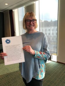 Foto av Annika Södergren som håller upp ett A4 ark med motiveringen till hennes utnämning årets FFS are 2021